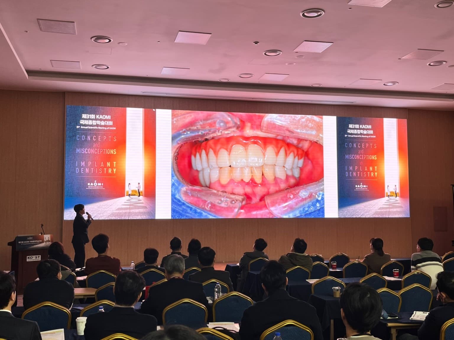 Dr. Soohyun Ko lecturing on full-arch implant cases at the 2024 KAOMI meeting